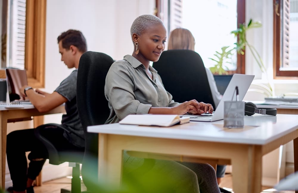 Professional woman sitting at computer working pleasantly.